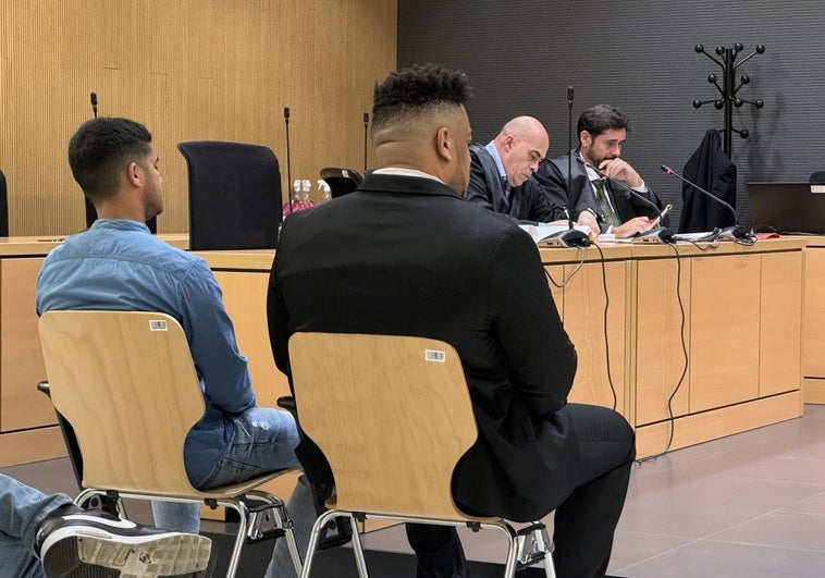Los dos acusados, de espaldas y sus letrados, al fondo durante la primera jornada de este juicio.