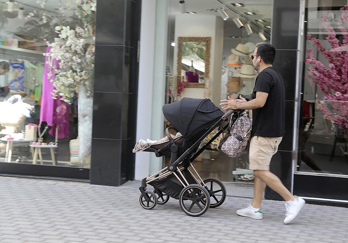 Padre paseando con un bebé de corta edad por el centro de Arrecife.