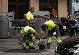 Imagen de archivo de varios operarios asfaltando un tramo de una carretera.