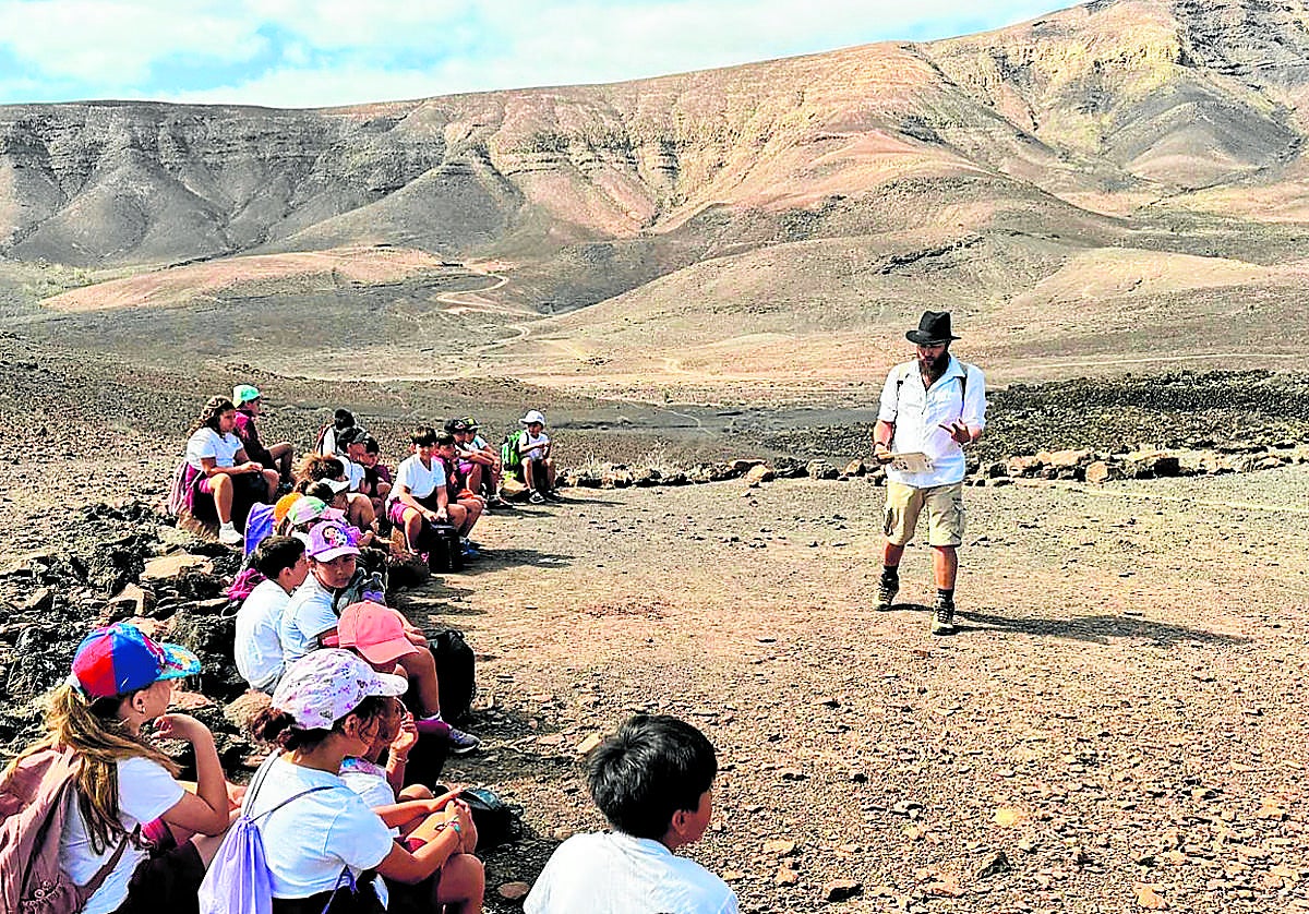 Derque Castellano, arqueólogo, explica el poblado de la Atalayita, en Pozo Negro, a los escolares.