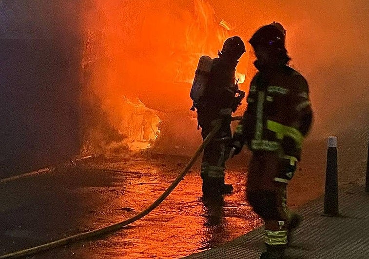 Imagen de los bomberos apagando el incendio en el vehículo.