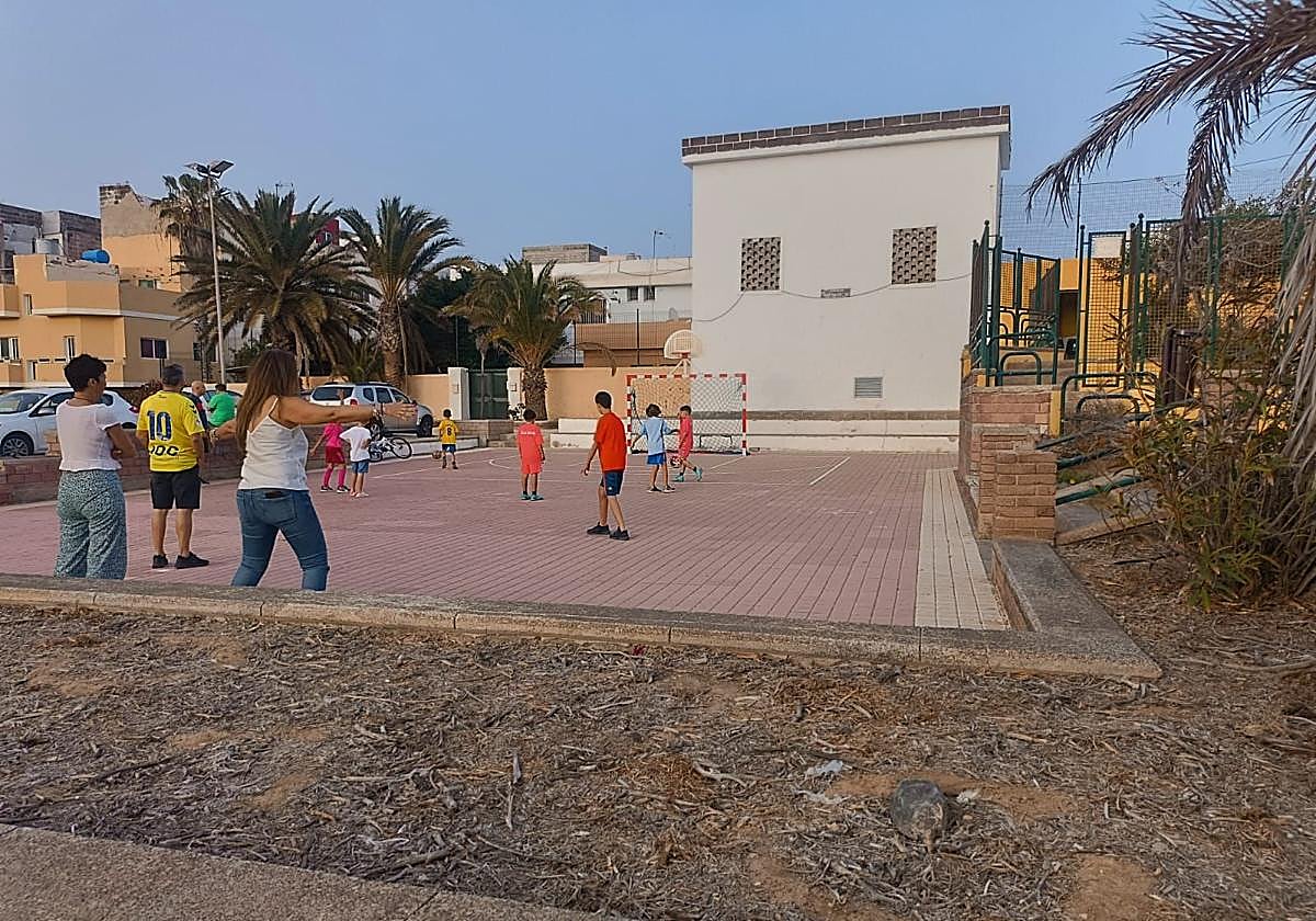 Los padres se colocan en un extremo de la cancha para evitar que los niños salten a la carretera persiguiendo los balones.