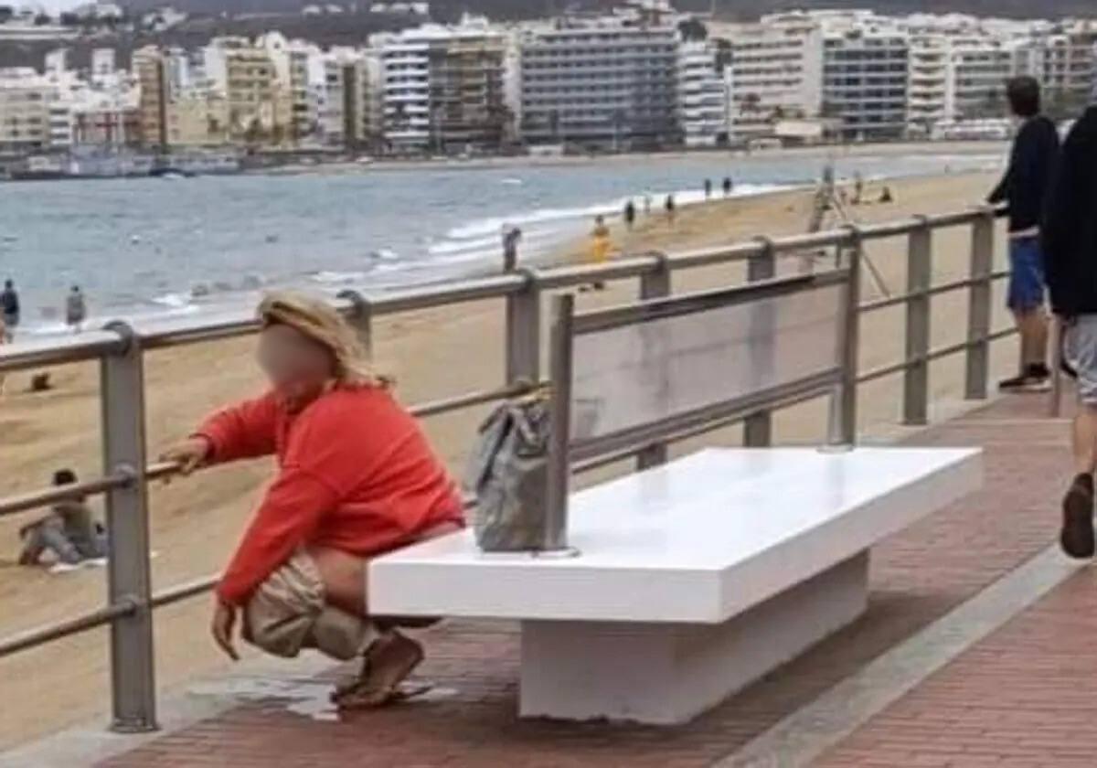 Señora miccionando en el paseo de Las Canteras.