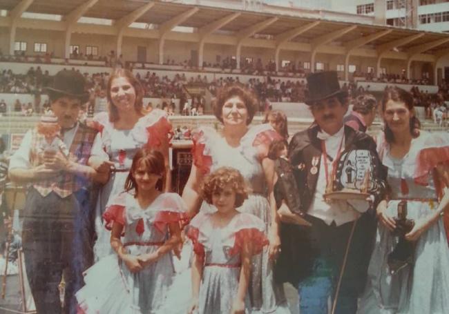 Imagen de la comparsa Nuevo Estilo en el Estadio Insular, en los ñao 80, junto a dos charlots.