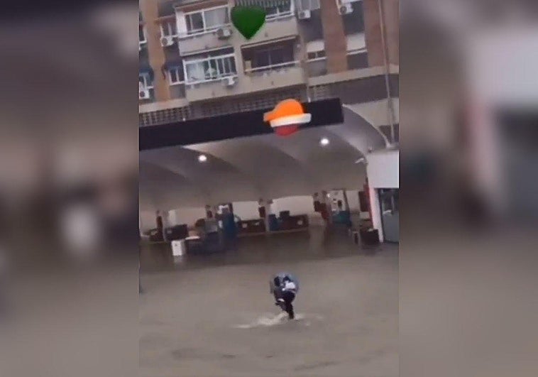Imagen de Mansour salvando a una mujer durante las fuertes lluvias de este miércoles en Málaga.