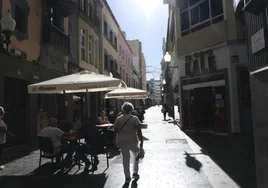 Una persona pasa junto a una terraza en Cano.