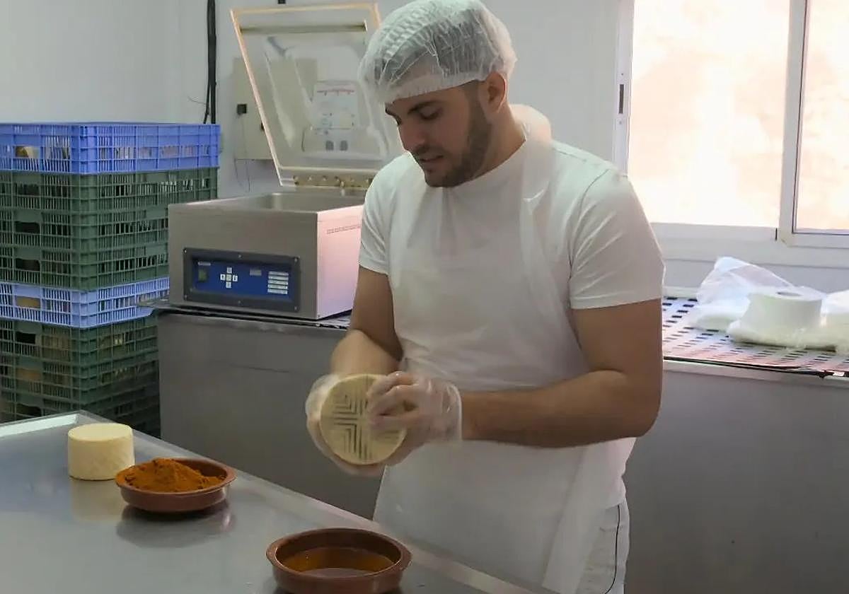 Rayco Ramos, de la ganadería Caprarius, en Mesque, unta un queso con pimentón y aceite.