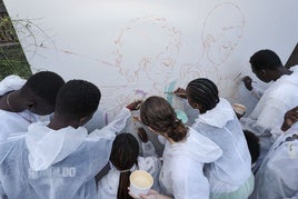 Parte del alumnado del IES La Isleta pintando un mural sobre integración que servirá como obsequio al papa Francisco.