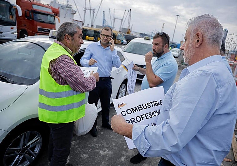 Los trabajadores del sector reparten pancartas para la protesta que arranca en el Muelle de Cambulloneros.