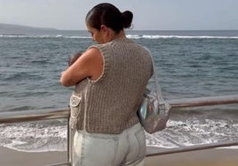 Anabel Pantoja sostiene a su hija en brazos en la playa de Las Canteras.