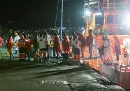 Trabajadores de la Cruz Roja reciben a las personas de un cayuco.