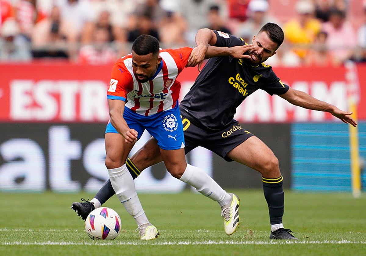 Kirian Rodríguez trata de robar el balón a un jugador del Girona en Montilivi.