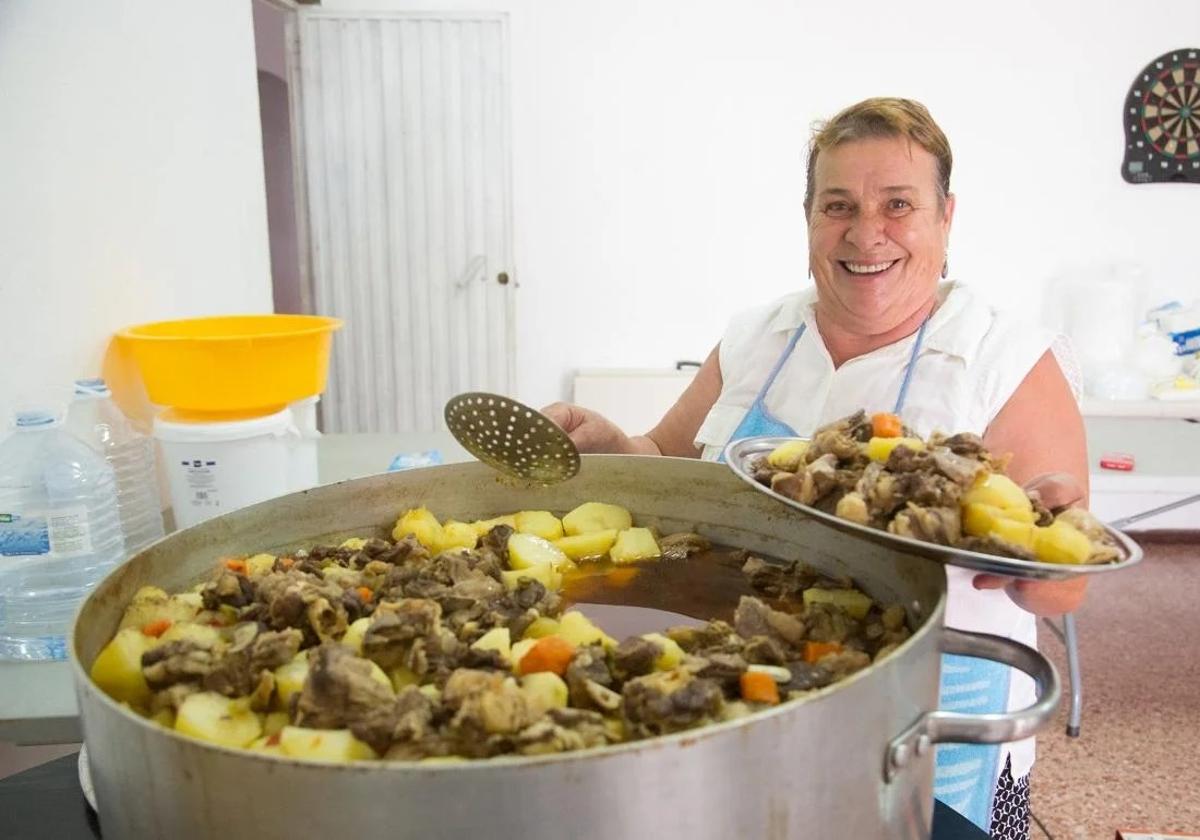 Mary Carmen, con una caldera de carne de cabra compuesta.