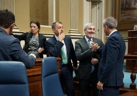 El presidente de Canarias, Fernando Clavijo (2d), saluda al vicepresidente y consejero de Economía, Manuel Domínguez (d) durante el último Pleno del pasado noviembre.