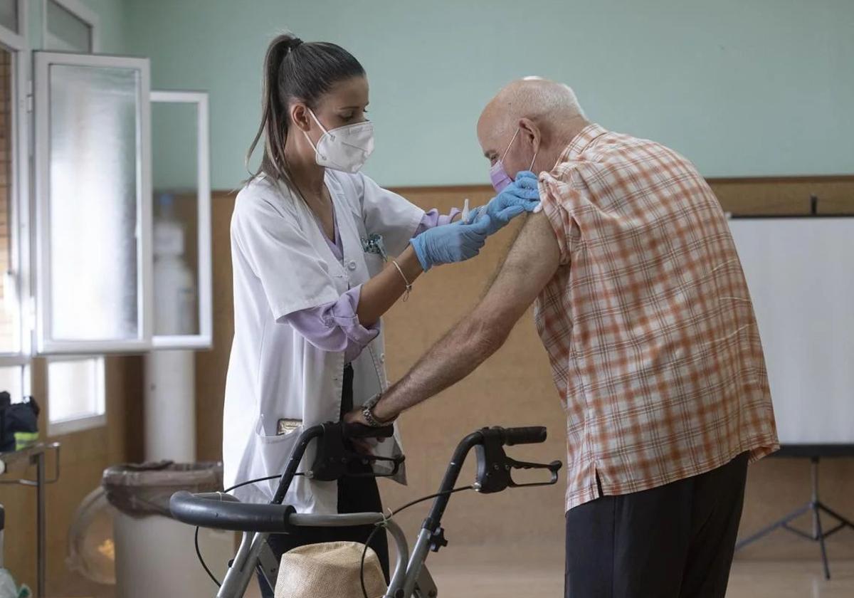 Enfermera vacunando a un paciente.