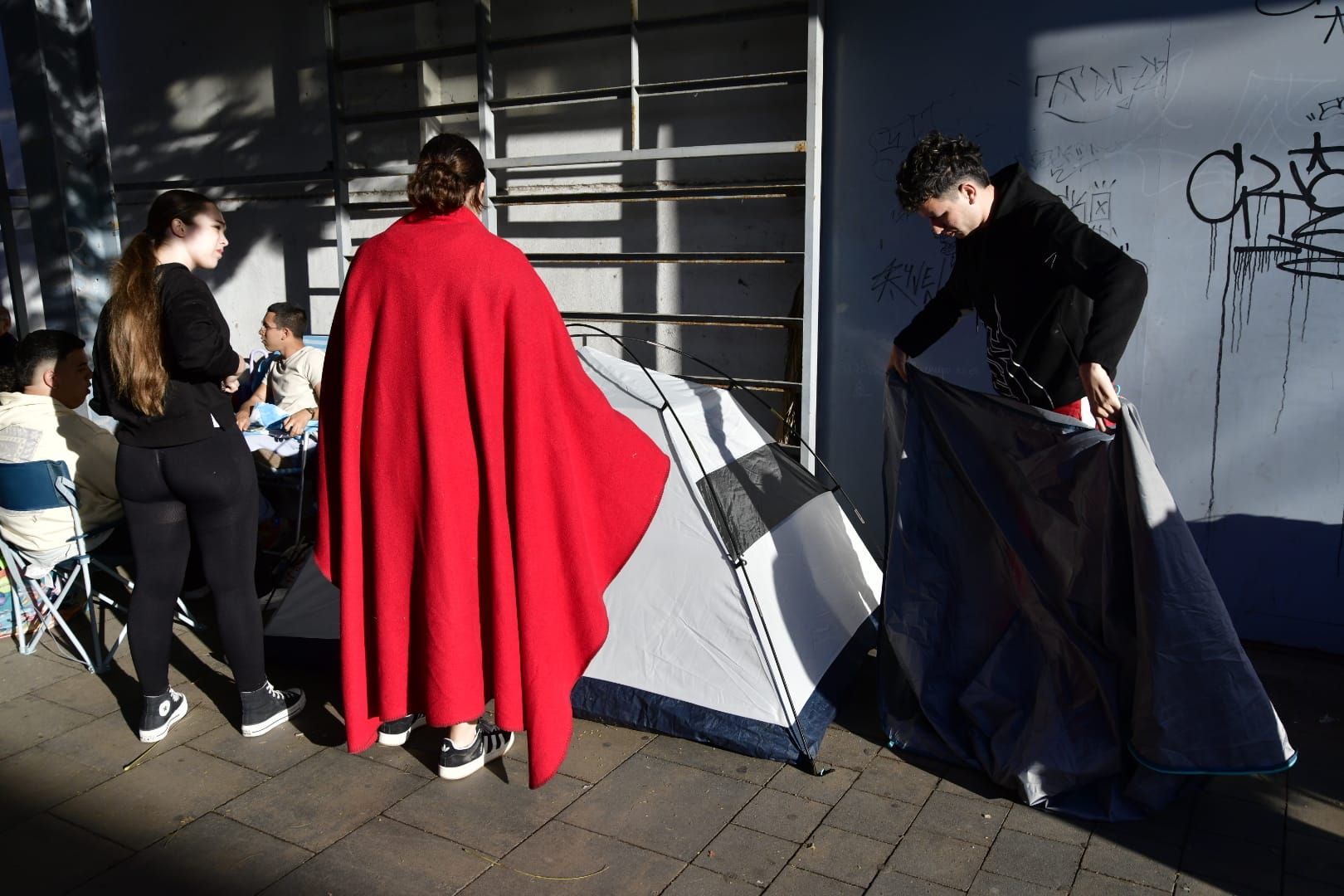 Tiendas de campaña bajo la lluvia por ver la gala drag