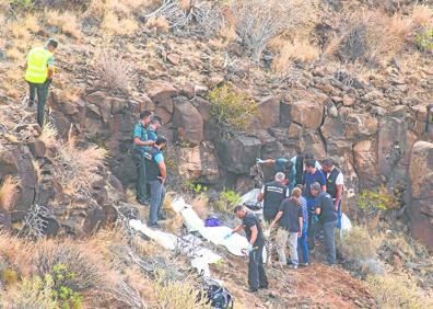 Imagen secundaria 1 - El vecino de Ingenio Carlos Díaz, con la perra que localizó los cuerpos en Temisas. Abajo, a la izquierda, La Guardia Civil durante la localización de los cadáveres, en Temisas; y a la derecha los restos mortales rescatados por la Guardia Civil.