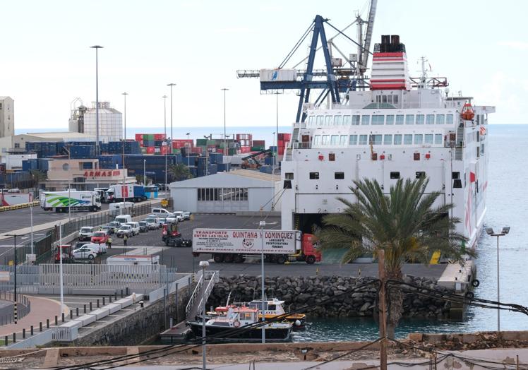 Camiones entrando en el ferry de Armas-Trasmediterránea en el muelle de Puerto del Rosario. Abajo, el buque de carga de Fred. Olsen.