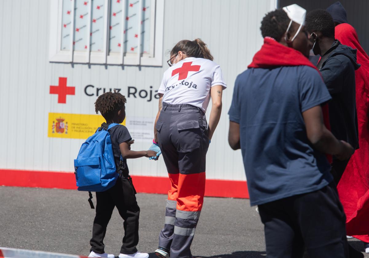 Un menor siendo atendido por una trabajadora de Cruz Roja en su llegada a Puerto del Rosario, Fuerteventura.