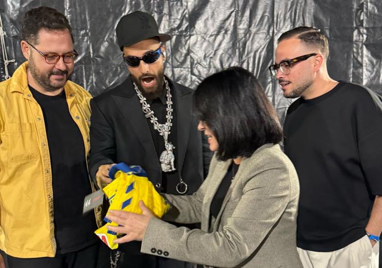 La alcaldesa, Carolina Darias, obsequia a Maluma con una camiseta de la UD Las Palmas en presencia del concejal Josué Íñiguez y el director del carnaval, Josué Quevedo.