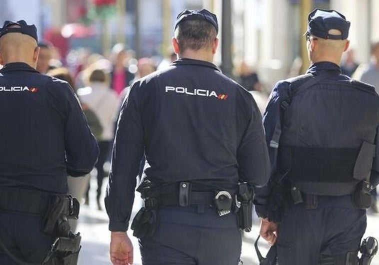 Tres policías nacionales patruyando por la calle.