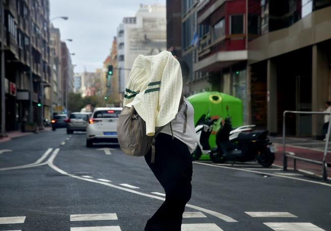 Mujer busca refugiarse de la lluvia por la borrasca Nuria.