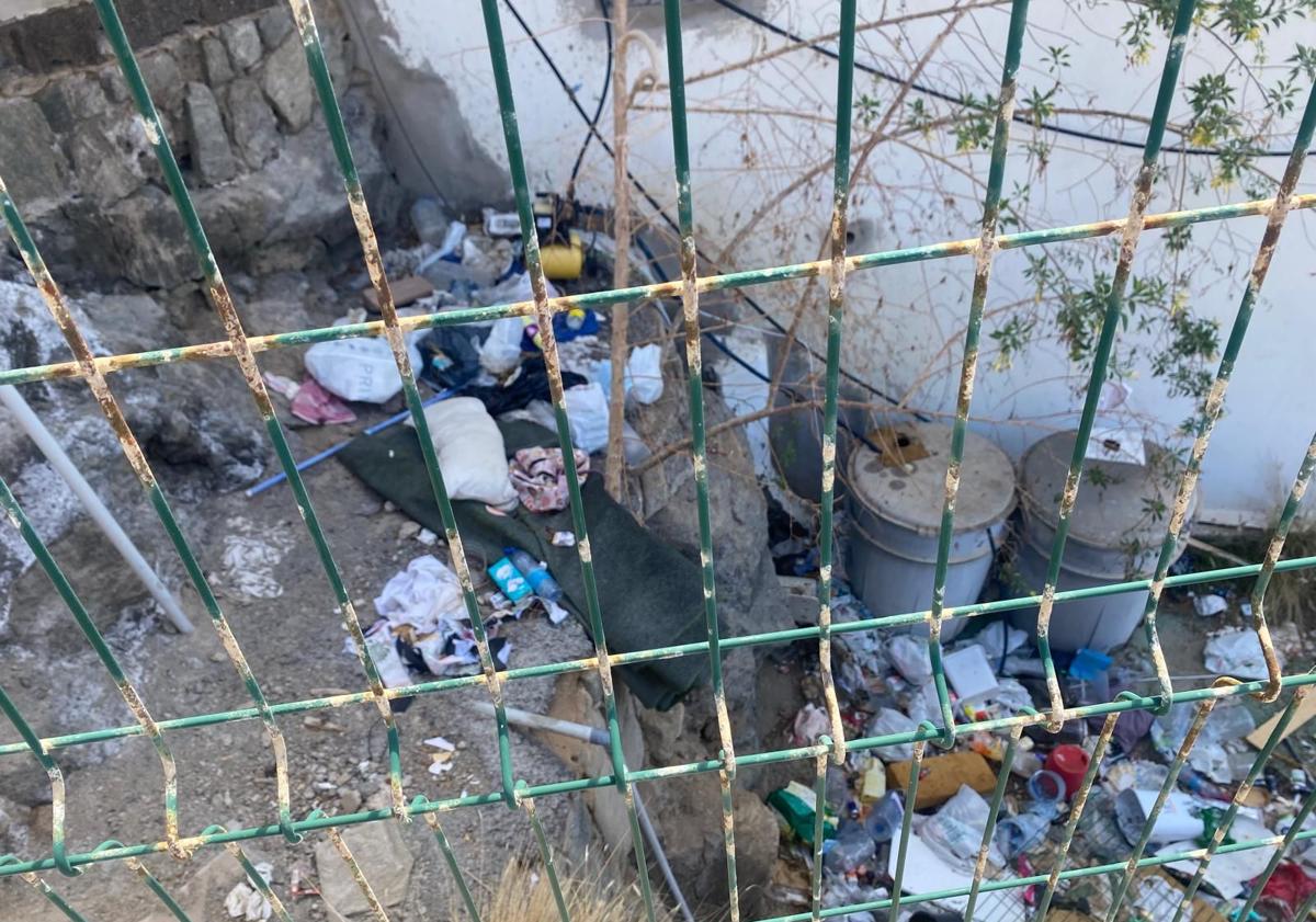 Imagen principal - Basura acumulada en los exteriores y dentro del complejo. En la foto vertical, tapias levantadas en la conexión de los apartamentos con las terrazas.