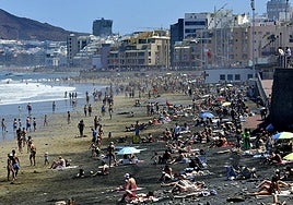 Imagen de la playa de Las Canteras repleta de personas y bañistas.