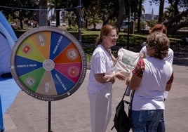 Una enfermera obsequia con una bolsa a un viandante y le explica las competencias de las profesionales, ayer en San Telmo.