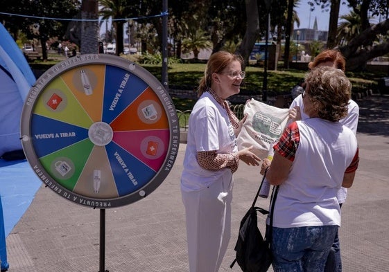 Una enfermera obsequia con una bolsa a un viandante y le explica las competencias de las profesionales, ayer en San Telmo.