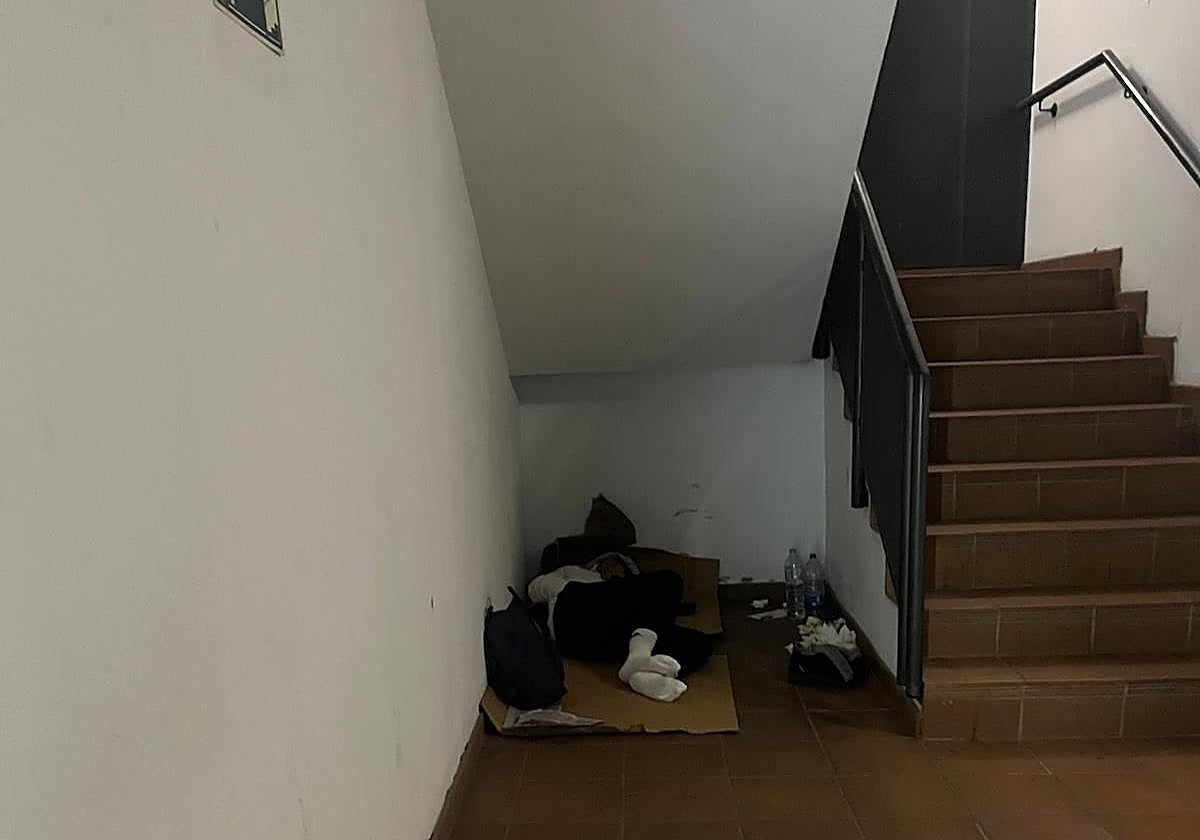 Imagen de una de las personas que duerme junto a la escalera del aparcamiento de los Nuevos Juzgados.
