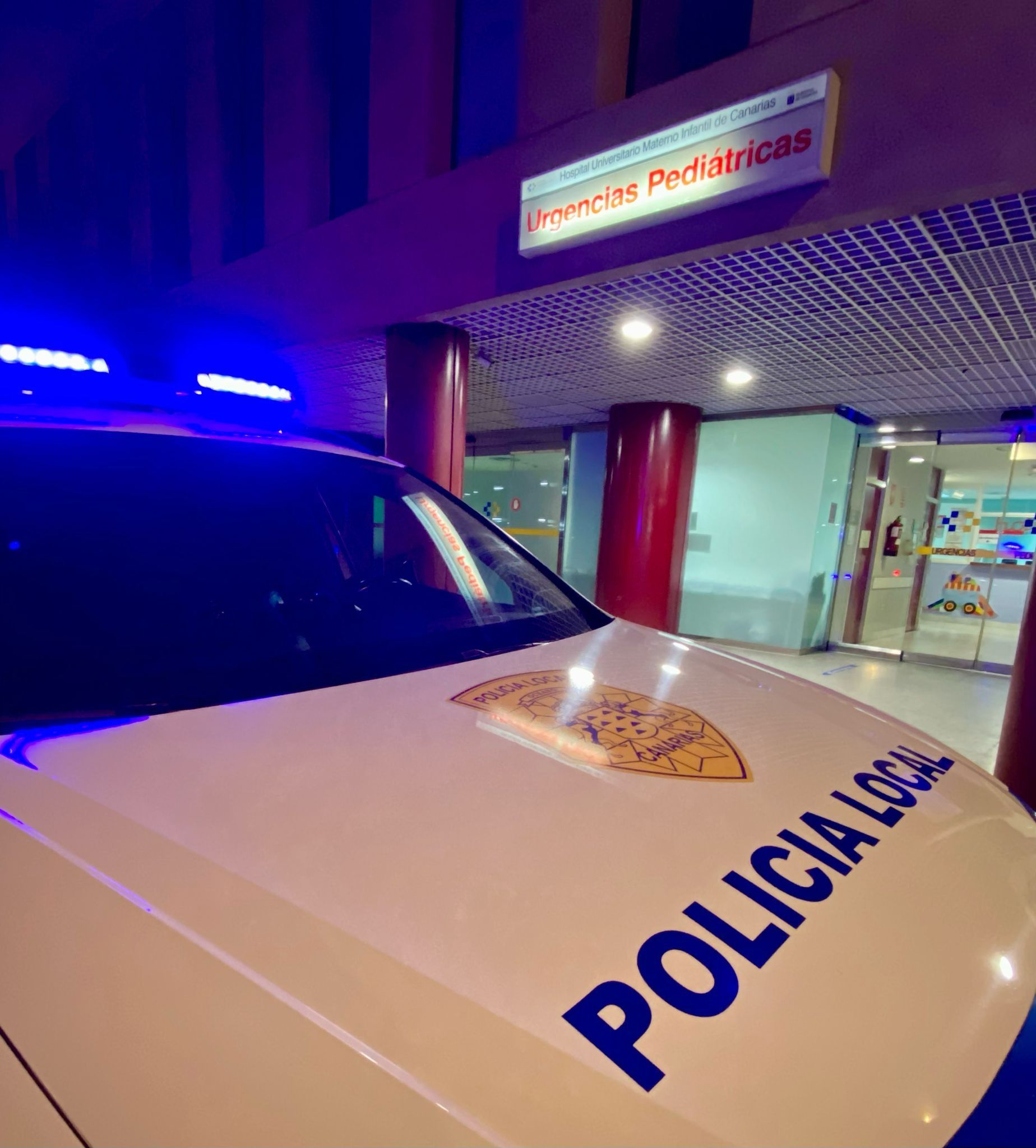 El coche de la Policía Local en el Materno tras el traslado del menor.