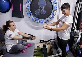 La fisioterapeuta Raquel Rodríguez (d) guía el ejercicio de Olga Mesa (i).