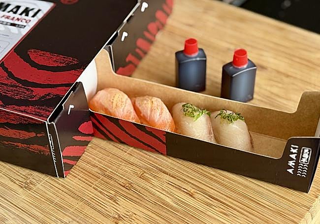 Niguiris de salmón y de vieiras soasadas en la caja de Amaki Daniel Franco