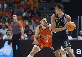 El alero argentino del Gran Canaria, Nicolás Brussino, protege el balón ante la defensa de Puerto.