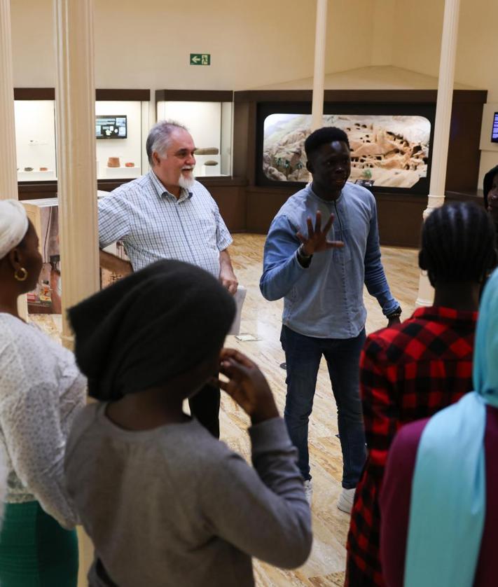 Imagen secundaria 2 - Momentos de la visita al Museo Canario, en Las Palmas de Gran Canaria. Ousmar Gassama, intérprete, Pepe López, voluntario de la asociación Culturas Unidas, (abajo izquierda) y Miguel Santana, historiador, fueron los encargados de explicar durante el recorrido. 