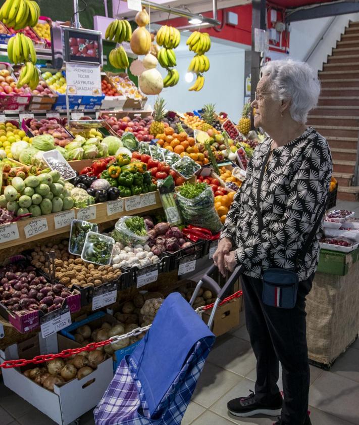 Imagen secundaria 2 - Ramón Guerra, en su puesto en el mercado de Altavista. Juan Manuel Martínez comprando. Y la vecina Bárbara Concepción.