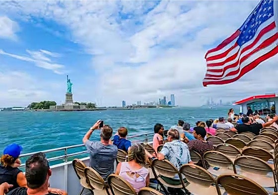 Turistas fotografiando la Estatua de la Libertad en Nueva York.