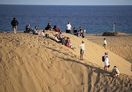 Foto de archivo de visitantes en lugares no permitidos de las dunas.