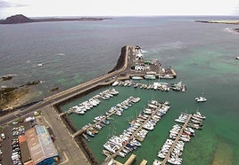 Muelle comercial y pesquero de Corralejo, en el municipio de La Oliva, con Lobos al fondo.