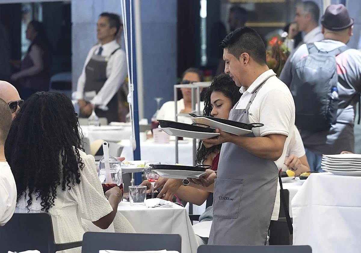 Un camarero atiende las mesas de un restaurante.