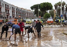 Vecinos, alcalde de Telde incluido, Juan Antonio Peña, achicando agua en la calle Américo Vespucio tras la riada.
