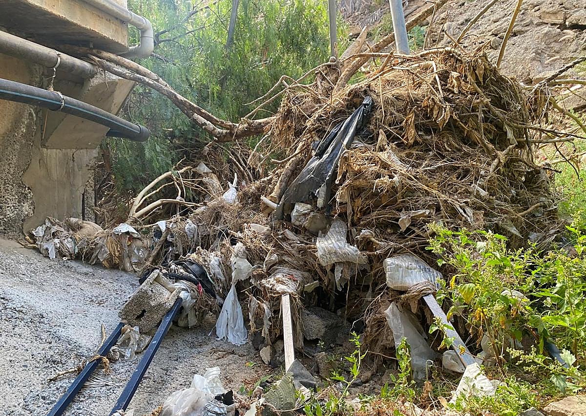 Imagen secundaria 1 - En la imagen superior, tres pequeños tubos, ahora taponados, por los que, se supone, ha de pasar el agua que baja por Las Manolitas. Debajo, efecto represa de varios postes en un punto donde una edificación redujo a un pasadizo al barranco de Las Manolitas. Y finalmente, boca de apenas 50 o 60 centímetros por la que la playa de Salinetas espera que pase todo lo que baje por el barranco.