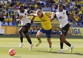 McBurnie, en el Gran Canaria forcejeando ante dos rivales del Valencia.