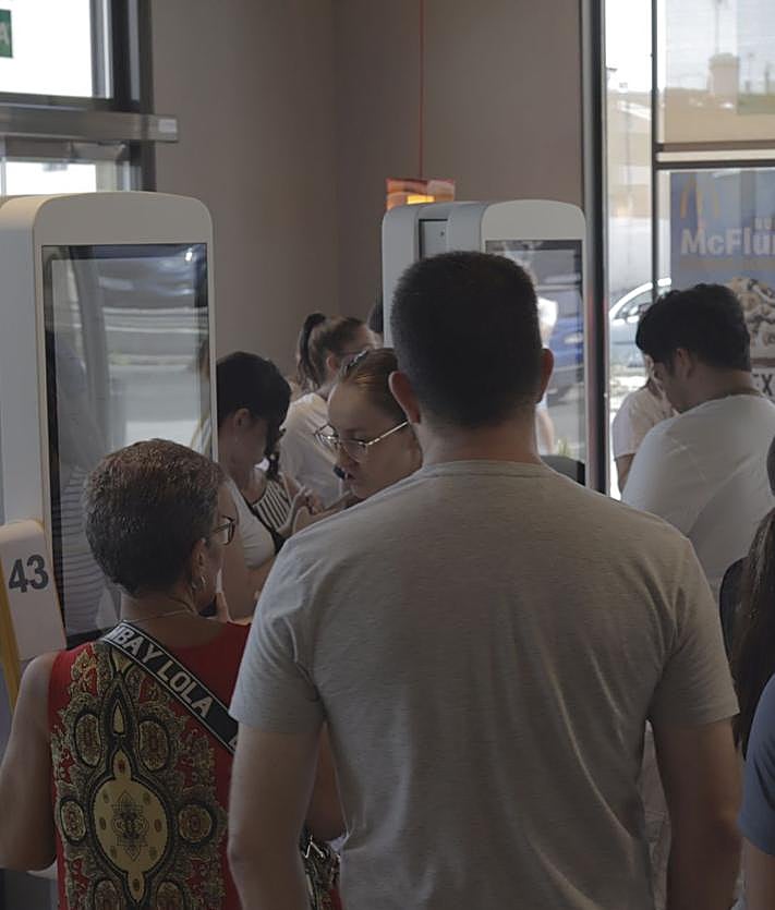 Imagen secundaria 2 - Parte del personal del nuevo local, actuación de Los Serenquenquenes y primeros clientes.