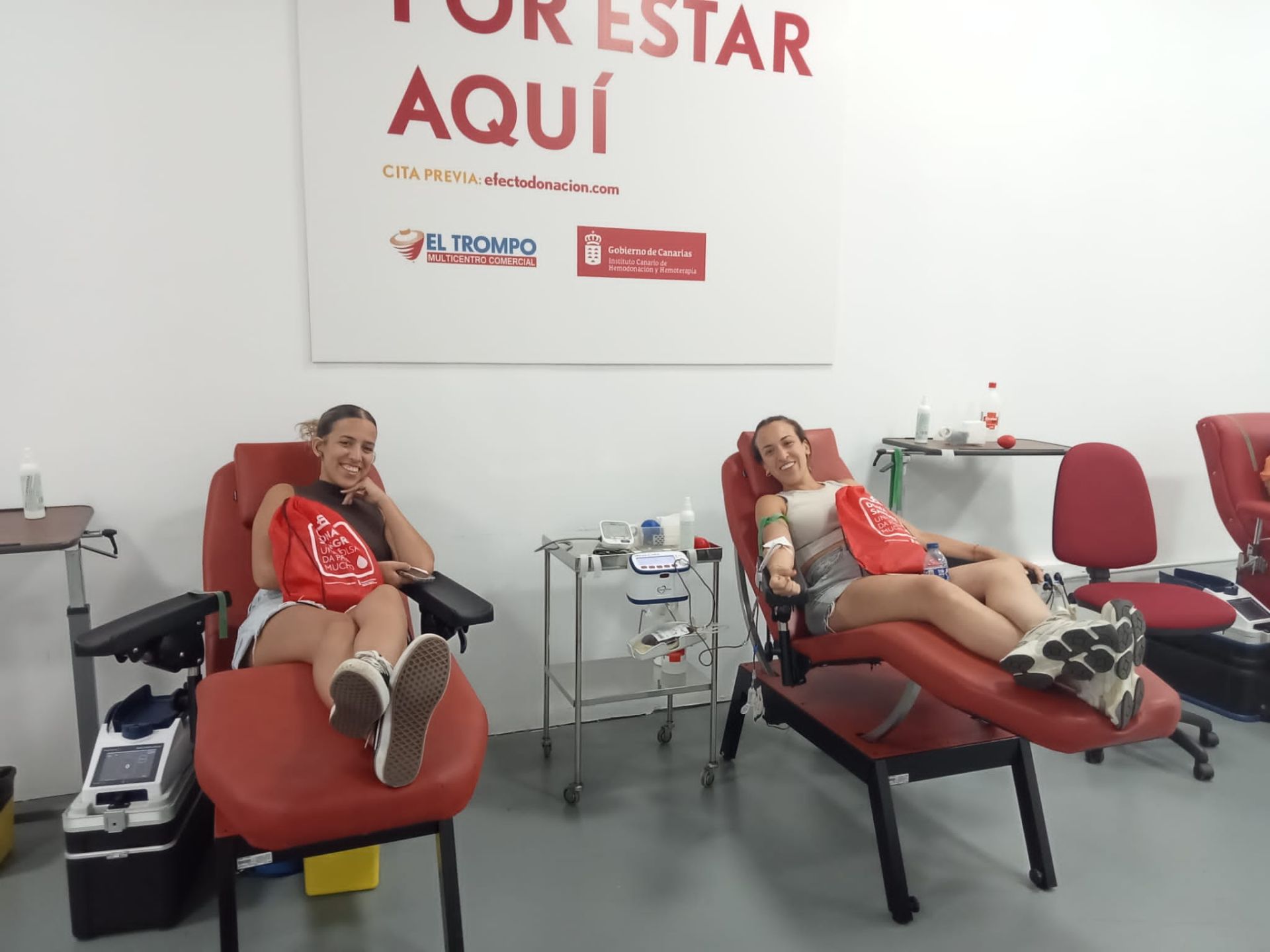 Dos chicas donan sangre.