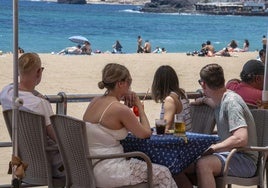 Un grupo de personas disfrutan de sus bebidas en una terraza de Las Canteras.