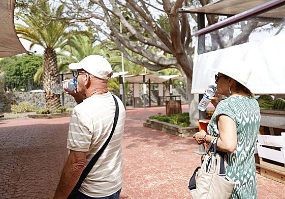 Dos personas se refrescan en San Lorenzo ente el calor.