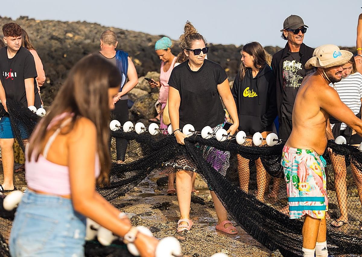 Imagen secundaria 1 - Las mujeres también jalaron del chinchorro, aunque desde tierra.