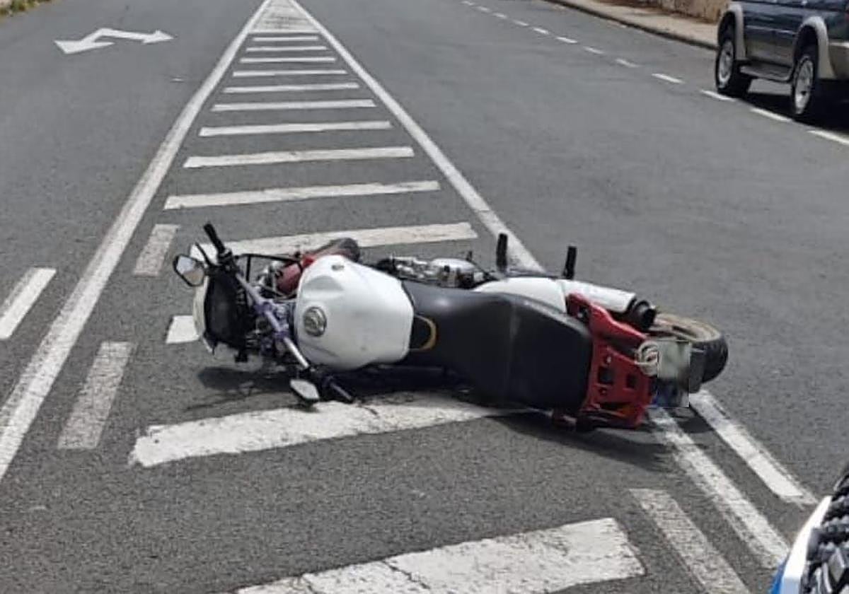 Imagen de la moto caída en el suelo.